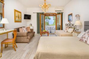 a bedroom with a bed and a living room at Leandros Hotel in Nea Roda