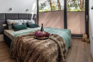 una camera con un letto e un cesto di frutta su una coperta di Domki Marzeń w Marzyszu z OPCJĄ Jacuzzi & Sauna a Marzysz