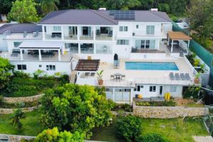 an aerial view of a large white house with a swimming pool at Olive Branch Villa *Luxury/ Fine Dining* in Oracabessa