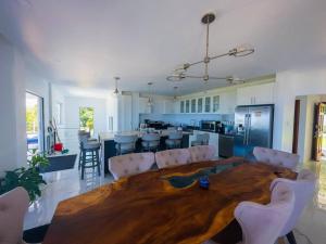 eine Küche und ein Wohnzimmer mit einem großen Holztisch in der Unterkunft Olive Branch Villa *Luxury/ Fine Dining* in Oracabessa
