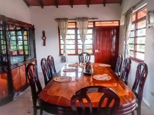 a dining room with a wooden table and chairs at Hostal Finca Villa Maria in Filandia