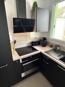 a small kitchen with a stove and a sink at Appartement avec Wifi La Baule Les Pins in La Baule