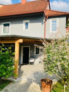 a house with a patio and a chair in front of it at Das Ferienhaus-zurück zum Ursprung in Güssing