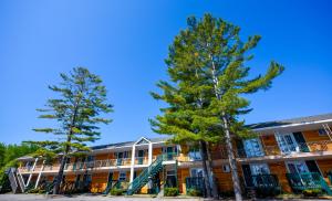 ein Gebäude mit zwei Bäumen davor in der Unterkunft Mackinac Lodge in Mackinaw City