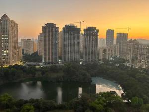 a city with a lake in front of a city skyline at London Studio @hiranandani thane in Thane