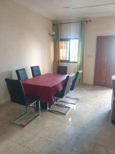 uma sala de jantar com uma mesa vermelha e cadeiras em Appart. For you N° 1. Douala Logpom sur le goudron em Douala