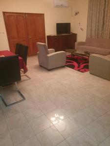 uma sala de estar com cadeiras, um sofá e uma mesa em Appart. For you N° 1. Douala Logpom sur le goudron em Douala