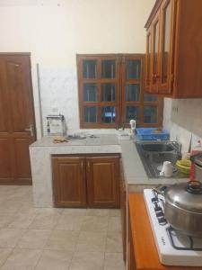 uma cozinha com armários de madeira e um forno com placa de fogão em Appart. For you N° 1. Douala Logpom sur le goudron em Douala