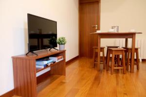 a living room with a flat screen tv and a table at Cabo do Mar Apart.- Sereias Beach in Espinho