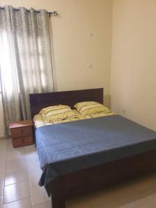 um quarto com uma cama com um colchão azul e uma janela em Appart. For you N° 1. Douala Logpom sur le goudron em Douala