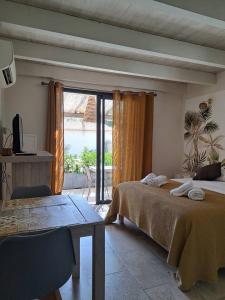 a bedroom with a bed and a table and a window at songes d été2 in Bonifacio