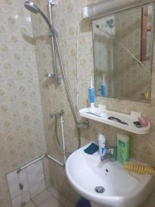 uma casa de banho com um lavatório e um chuveiro com um espelho. em Appart. For you N° 1. Douala Logpom sur le goudron em Douala