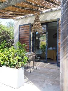 a patio with a chair and a table and a bed at songes d été2 in Bonifacio