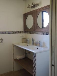 La salle de bains est pourvue d'un lavabo blanc et de deux miroirs. dans l'établissement songes d été2, à Bonifacio