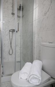 ein Bad mit einer Dusche, einem WC und Handtüchern in der Unterkunft Cabo do Mar Apart.- Sereias Beach in Espinho