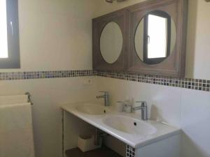 a bathroom with a sink and two mirrors at songes d été2 in Bonifacio