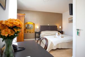 a bedroom with a bed and a table with a vase of flowers at Bed & Breakfast Vila Baguc in Split