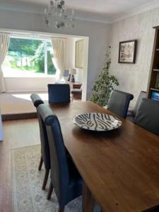 a wooden dining room table with blue chairs and a dining room at Home in Midsomer Norton, near Bath & Bristol in Midsomer Norton