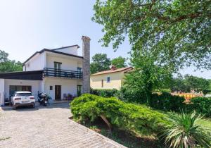 a house with a car parked in front of it at Apartments Villa Verde in Novigrad Istria