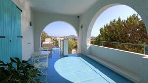 - un balcon avec deux arches, une table et des chaises dans l'établissement Villa Tre Mari, à Villasimius