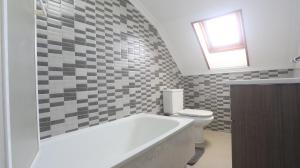a bathroom with a tub and a toilet and a window at Ático Laxe Grande in A Guarda +47 photos