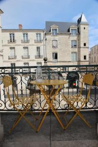 uma mesa e cadeiras numa varanda com um edifício em Très lumineux, au coeur de la vieille ville, 86 m² em La Rochelle