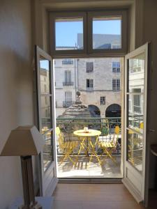 um quarto com uma varanda com uma mesa e uma vista em Très lumineux, au coeur de la vieille ville, 86 m² em La Rochelle