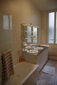 uma casa de banho com uma banheira e 2 lavatórios e uma banheira em Très lumineux, au coeur de la vieille ville, 86 m² em La Rochelle