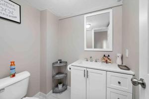 ein weißes Badezimmer mit einem Waschbecken und einem Spiegel in der Unterkunft Overnight in Merriam