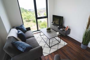 a living room with a couch and a tv and a table at Modern 2-Beds - City Centre - FREE Wi-Fi - New - in Sheffield