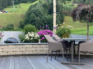 einen Tisch und Stühle auf einer Terrasse mit Blumen in der Unterkunft Laudinella - Apart in See