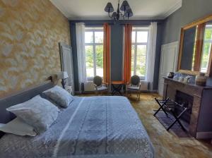 Schlafzimmer mit einem Bett, einem Kamin und Fenstern in der Unterkunft Maison Grandsire Chambres D'Hôtes in Saint-Léonard