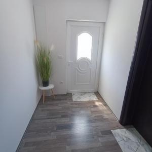 a hallway with a white door and a potted plant at Holiday Apartmant in Primošten