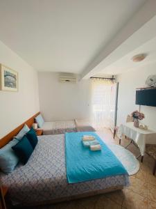 een slaapkamer met een blauw bed en een tafel bij Miomir Perazic Apartments in Petrovac na Moru