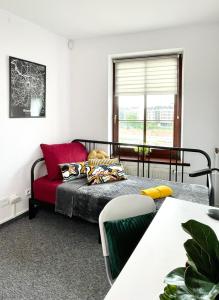 ヴロツワフにあるPro-Invest Houseのベッドルーム1室(ベッド1台、赤いソファ付)