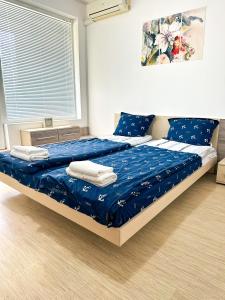 a bedroom with a bed with blue sheets and a window at Sunshine Romance Apartment in Kranevo