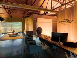 a room with a desk with a television and chairs at Lavandeira Douro Nature & Wellness in Ancede