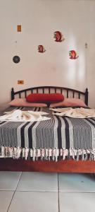 a bed with a black and white striped comforter and pillows at Serrambi Praia Suites in Porto De Galinhas