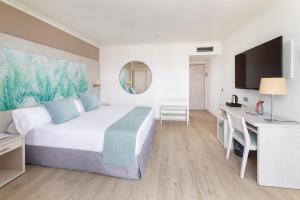 a hotel room with a bed and a desk and a television at Tigotan Lovers & Friends Playa de las Americas - Adults Only (+18) in Playa de las Americas +37 photos