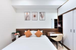 a bedroom with a bed and a desk and a chair at January Apartment in Ho Chi Minh City