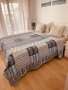 ein Bett mit einer Decke in einem Schlafzimmer in der Unterkunft Sunny apartment Sa Boadella big solarium sea view in Lloret de Mar