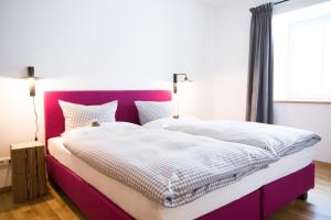 a bedroom with a large bed with a purple headboard at Guade Stub´n in Garmisch-Partenkirchen