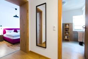 a mirror on a wall in a room with a bed at Guade Stub´n in Garmisch-Partenkirchen