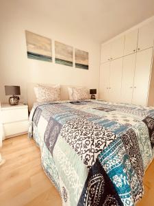 um quarto com uma cama com uma colcha azul e branca em Sunny apartment Sa Boadella big solarium sea view em Lloret de Mar