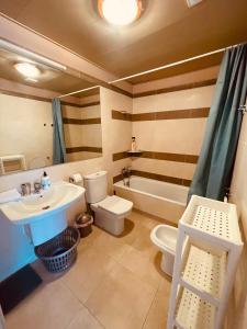 een badkamer met een wastafel, een toilet en een bad bij Sunny apartment Sa Boadella big solarium sea view in Lloret de Mar