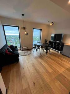 a living room with a couch and a table at Amazing High-Rise 1BR with 11th Floor Views in Tallinn
