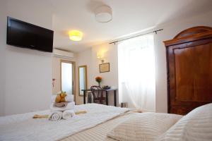 a bedroom with a bed with a tv on the wall at Bed & Breakfast Vila Baguc in Split