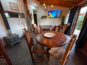 a dining room with a table and chairs and a stove at Fario Fishing Lodge in Villa El Chocón