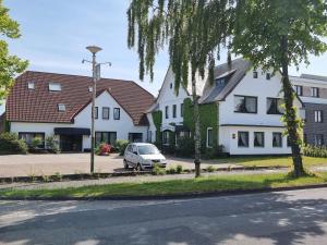 uma fila de casas com um carro estacionado na rua em Hotel Rademacher em Wittmund