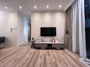 a living room with a tv on the wall at Hanns Spacious Balcony&SwimPool with FREE Netflix-6pax in Sibu